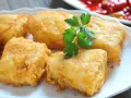 Crujientes trozos de merluza a la romana, dorados y listos para disfrutar. Un clásico plato español.