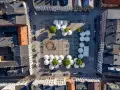 Widok z lotu ptaka na rynek w Kościerzynie, z białymi parasolami i zielenią.