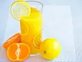 Succo d'arancia e limone, ricchi di vitamina C, in un bicchiere con fette di agrumi.