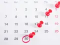 Kalendarz z zaznaczonym 30 dniem, przypominający o ważnym wydarzeniu w lipcu (july). Czerwone pinezki oznaczają inne daty.