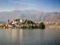 Isola di San Giulio, uno dei più bei posti da visitare in Piemonte, con il suo borgo antico sul lago d'Orta e le montagne sullo sfondo.