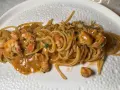 Spaghetti cremosi con mazzancolle e prezzemolo tritato, un piatto invitante e saporito.