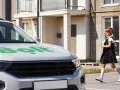 Dziewczynka w szkolnym mundurku biegnie do białego samochodu z logo Bolt. Spełnia wymagania komfortu podróży.