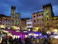 Un magico Arezzo tour: mercatini natalizi illuminati da proiezioni artistiche su torri e palazzi storici.