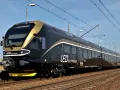 Nowoczesny, czarny pociąg LEO Express ze złotymi akcentami na torach.