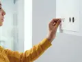 Donna regola il termostato per impostare la temperatura acqua sanitaria a 40 gradi.