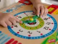Kind lernt Uhrzeit: Zeiger auf 9, wie bringe ich meinem Kind die Uhr bei? Bunte Lernuhr mit Marienkäfer.