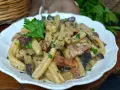 Un piatto invitante di pasta alla boscaiola con funghi e pancetta, guarnito con prezzemolo fresco.