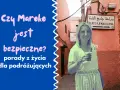 Uśmiechnięta kobieta z tatuażem henny na ręce pozuje na tle uliczki w Maroku. Tekst pyta: "Czy Maroko jest bezpieczne?".
