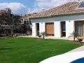 Modern villa con césped artificial en terrazas. Ideas para jardines de bajo mantenimiento y aspecto impecable.