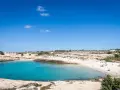 La **Cala Croce a Lampedusa** offre acque cristalline e una spiaggia dorata, ideale per rilassarsi sotto il sole.