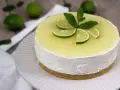 Cheesecake al mojito fresca e profumata, decorata con fettine di lime e menta.