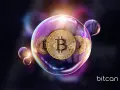 Złote monety Bitcoin w bańce mydlanej symbolizują, co to jest blockchain – bezpieczną, rozproszoną księgę transakcji.