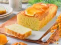 Un delicioso bizcocho de naranja, recién horneado y decorado con rodajas de naranja. Perfecto para acompañar un café.