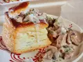 Une bouchée à la reine au veau, garnie de morceaux de veau et de champignons dans une sauce crémeuse, servie sur une assiette décorée.