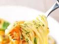 Un primo piatto invitante: spaghetti con gamberetti succulenti e prezzemolo fresco, pronti per essere gustati.