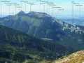 Giewont, majestatyczny szczyt Tatr, wznosi się na 1867 m. Widok obejmuje stoki, doliny i wyciągi krzesełkowe.