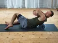 Mann nutzt eine Faszienrolle zur Selbstmassage des Rückens. Die Anwendung der Faszienrolle hilft bei der Lockerung verspannter Muskeln.