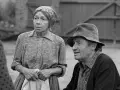 Marta Ławińska w stroju ludowym, obok mężczyzny w kapeluszu, w scenerii wiejskiej.