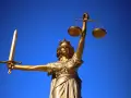 Złota Temida z mieczem i wagą, symbol sprawiedliwości, jak europejski tytuł egzekucyjny.