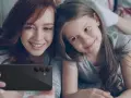 Mama i córka robią selfie telefonem. Od ilu lat można mieć telefon? Odpowiedź zależy od rodziców i dziecka.