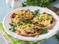 Schab w plastrach pieczony w piekarniku z pieczarkami i serem, posypany szczypiorkiem.