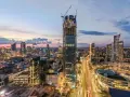 Varso Tower w budowie, otoczony innymi wieżowcami Warszawy o zmierzchu.
