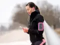 Donna con fascia da braccio rosa per il telefono, ideale per sapere dove mettere il telefono quando si corre.