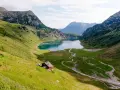 Idyllischer Salzburg See, umgeben von grünen Bergen. Eine Hütte am Hang lädt zum Verweilen ein.