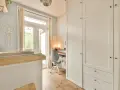 Un angolo studio in camera da letto, con scrivania, sedia girevole e armadio bianco.