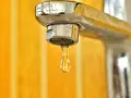Goccia d'acqua fredda dal rubinetto cromato. La caldaia non esce acqua calda, un problema comune in casa.