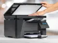 Dłonie zamykają pokrywę skanera, przygotowując go do pracy. To urządzenie to skaner przeznaczenie do digitalizacji dokumentów.