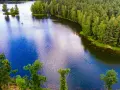 Malownicze jezioro z wyspą i żaglówkami, otoczone lasem. To jedno z najpiękniejszych miejsc Kujawsko-Pomorskiego.