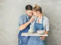 Para uczciła 9 rocznicę ślubu, tworząc ceramikę. Mężczyzna dotyka nosem twarzy kobiety, oboje ubrani w fartuchy, pokryci gliną.