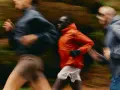 Trois coureurs en mouvement dans un décor forestier, suivant un programme reprise course à pied.
