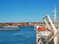 Widok z promu na Bornholm. Widać port, miasteczko z czerwonymi dachami i kościołem, a na pierwszym planie łódź ratunkową.