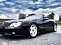 Czarny Mercedes SL R230 na parkingu. Nawet klasyki mają swoje **awarie i problemy**, ale ten wciąż wygląda świetnie.