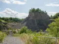 Kamieniołom przypomina wilczą górę, z której wyrasta bujna zieleń. Ścieżka prowadzi w głąb skalistego krajobrazu.