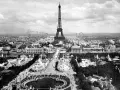 Vista panorámica del **Champ de Mars** con la Torre Eiffel dominando el paisaje, rodeada de pabellones y una noria.