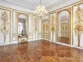 Salón dorado del museo Carnavalet, con suelo de parqué, candelabro de cristal y ornamentación dorada en las paredes.