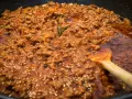 Un saporito ragù di lepre cuoce lentamente in padella, con un rametto di rosmarino che profuma l'aria.