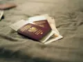 Kilka paszportów leży na szarym materiale. Zastanawiasz się, ile czeka się na paszport w Polsce?