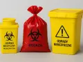 Żółte pojemniki i czerwony worek z symbolem biohazard. Oznaczenia wskazują na kod odpadów medycznych 18 01 03.