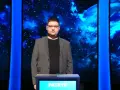 Patryk w szarym garniturze stoi przed niebieskim tłem z gwiazdami.