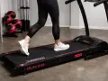 Person springer intervaller på löpbandet "RUN 2.0". Träningsredskap i bakgrunden.