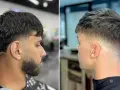 Zwei Männer mit stylischem taper cut. Der linke hat dunkles Haar und Bart, der rechte helleres Haar.