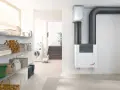 Sistema de ventilación con recuperación de calor Zehnder ComfoAir Q, con tuberías grises y un diseño blanco moderno.