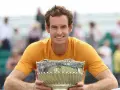 Andy Murray sonríe con un trofeo plateado, un reflejo de su impresionante palmarés.