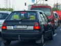 Czarny samochód z indywidualnymi tablicami rejestracyjnymi "WO LUXUS" w korku ulicznym.