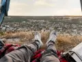 Nogi w butach sportowych na tle malowniczego krajobrazu z miasteczkiem. Wspaniały widok z namiotu podczas **camping portugalia**.